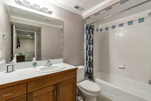 Bathroom with shower / tub combo with curtain, ornamental molding, and vanity