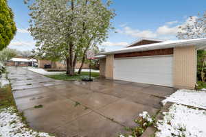 Ranch-style house featuring brick siding, driveway, and an attached garage