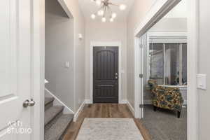 Foyer with suspended lighting and light wood finished floors