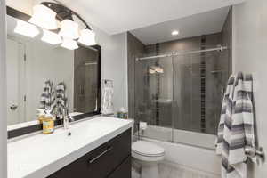 Full bath featuring vanity and enclosed tub / shower combo