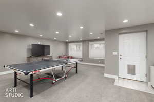 Recreation room featuring light colored carpet and recessed lighting.  Walk-out basement into back yard.