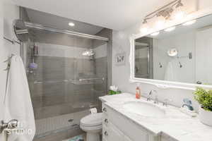 Full bathroom with vanity, a stall shower, and recessed lighting
