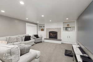 Living room featuring built in features, recessed lighting, a tile fireplace, and carpet flooring