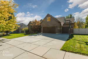 Traditional-style house with a garage, driveway, brick siding, and a gate