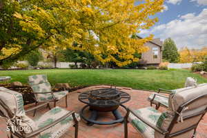 Fenced backyard with a fire pit and a patio