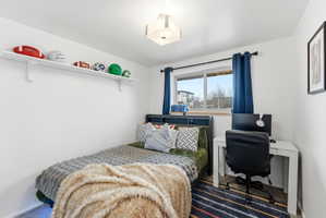 Carpeted bedroom featuring a desk