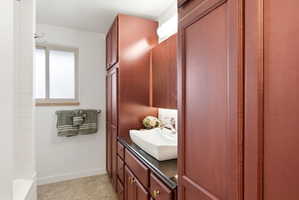 Full bath featuring vanity and baseboards