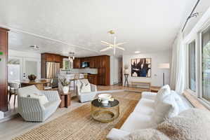 Living room featuring light wood-style floors and a textured ceiling