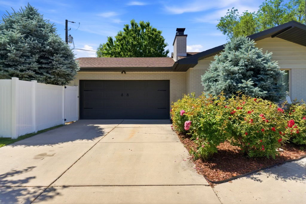 Concrete driveway leading to an attached garage with dark brown door