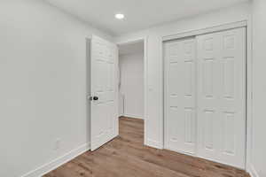 Unfurnished bedroom with light wood-style floors and a closet