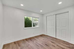 Unfurnished bedroom with a closet, light wood-style flooring, and recessed lighting