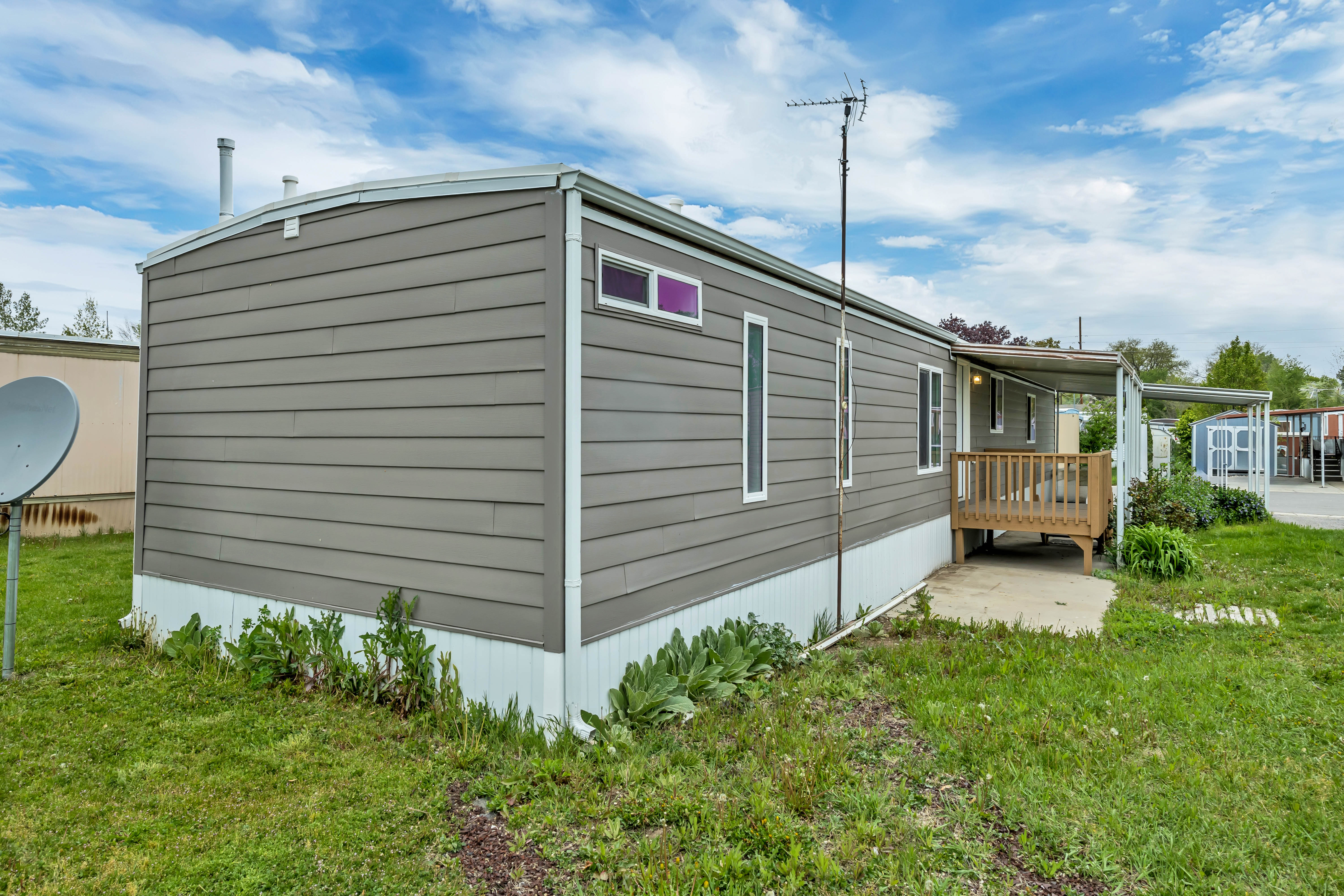 View of side of home featuring a lawn and an outdoor structure