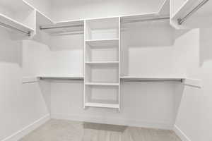 Walk in closet featuring light carpet