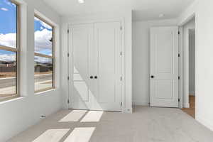 Unfurnished bedroom with light carpet, a closet, and recessed lighting