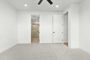 Unfurnished bedroom with light carpet, recessed lighting, ceiling fan, and ensuite bath