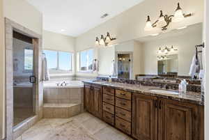 Primary bathroom with separate tub & shower, double vanity, light travertine floors,