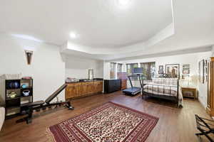 Exercise and dance room, dark wood flooring and a raised ceiling
