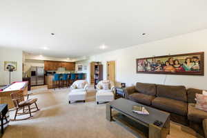 Lower level family room with light carpet, healthy amount of natural light, and 2nd kitchen
