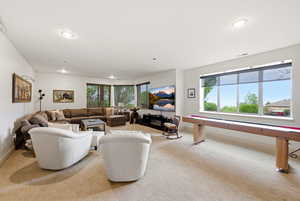 Lower level family room with light carpet, healthy amount of natural light, and 2nd kitchen