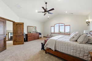 Primary bedroom featuring lofted ceiling, light colored carpet, a ceiling fan, and recessed lighting