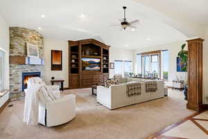 Living area with ceiling fan, a fireplace, inlaid floor details, lofted ceiling, and recessed lighting