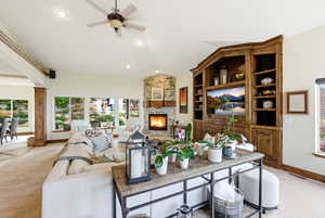 Living area featuring ceiling fan,  fireplace, cozy light carpet, and recessed lighting