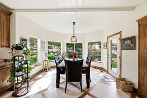 Dining room featuring inlaid floor details and beamed ceiling