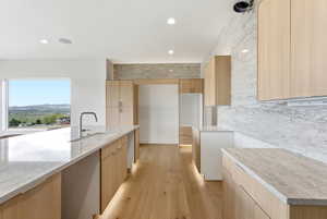 Kitchen with light wood-style floors, modern cabinets, light stone countertops, light wood finish cabinetry, and recessed lighting