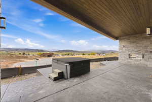 View of patio featuring a mountain view and a hot tub
