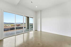 Empty room featuring a mountain view, recessed lighting, and concrete floors