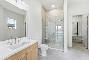 Full bath with vanity, a shower stall, and light tile patterned floors