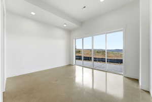 Empty room with recessed lighting and concrete flooring