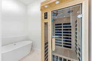 Relaxing sauna / steam room with tile patterned flooring and recessed lighting