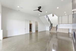 Unfurnished living room featuring ceiling fan, finished concrete flooring, and recessed lighting