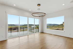 Spare room with a mountain view, recessed lighting, light wood finished floors, and healthy amount of natural light