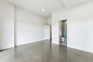 Empty room featuring concrete flooring and baseboards