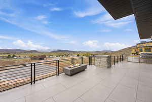 View of patio / terrace featuring an outdoor kitchen, a mountain view, and a fire pit