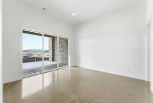 Unfurnished room with a mountain view, concrete flooring, and recessed lighting
