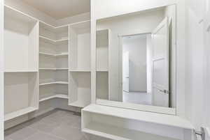 Walk in closet with light tile patterned flooring