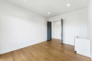 Unfurnished room featuring wood finished floors and recessed lighting