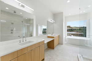 Full bath with a stall shower, double vanity, a soaking tub, recessed lighting, and light tile patterned floors