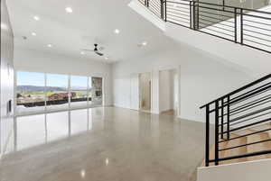 Spare room featuring finished concrete flooring, a mountain view, recessed lighting, a high ceiling, and ceiling fan