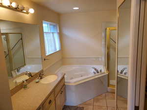 Full bath with vanity, a whirlpool tub, a shower stall, light tile patterned floors, and recessed lighting