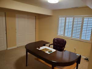 Home office with carpet and baseboards