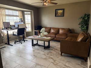 Home office with light marble finish flooring and ceiling fan