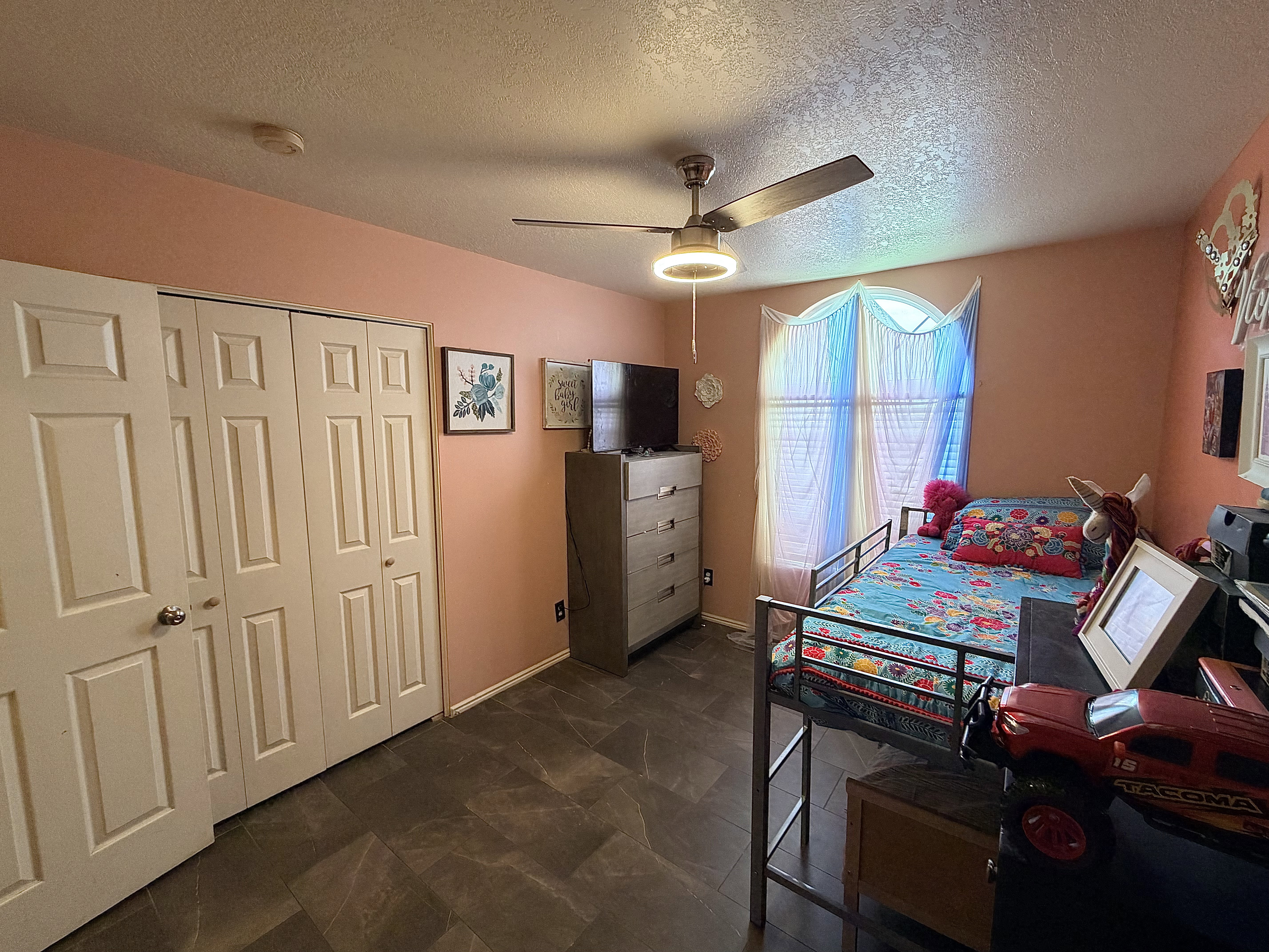 Bedroom with a closet, a ceiling fan, and a textured ceiling