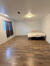 Bedroom featuring dark wood-style flooring and a textured ceiling