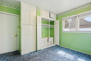 Unfurnished bedroom with carpet flooring and two closets