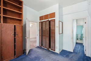 Unfurnished bedroom with dark colored carpet and a closet