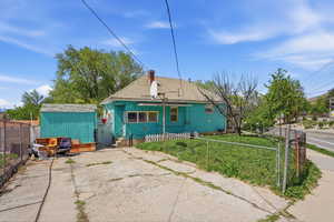 Back of property featuring a fenced front yard, a storage shed, and a chimney